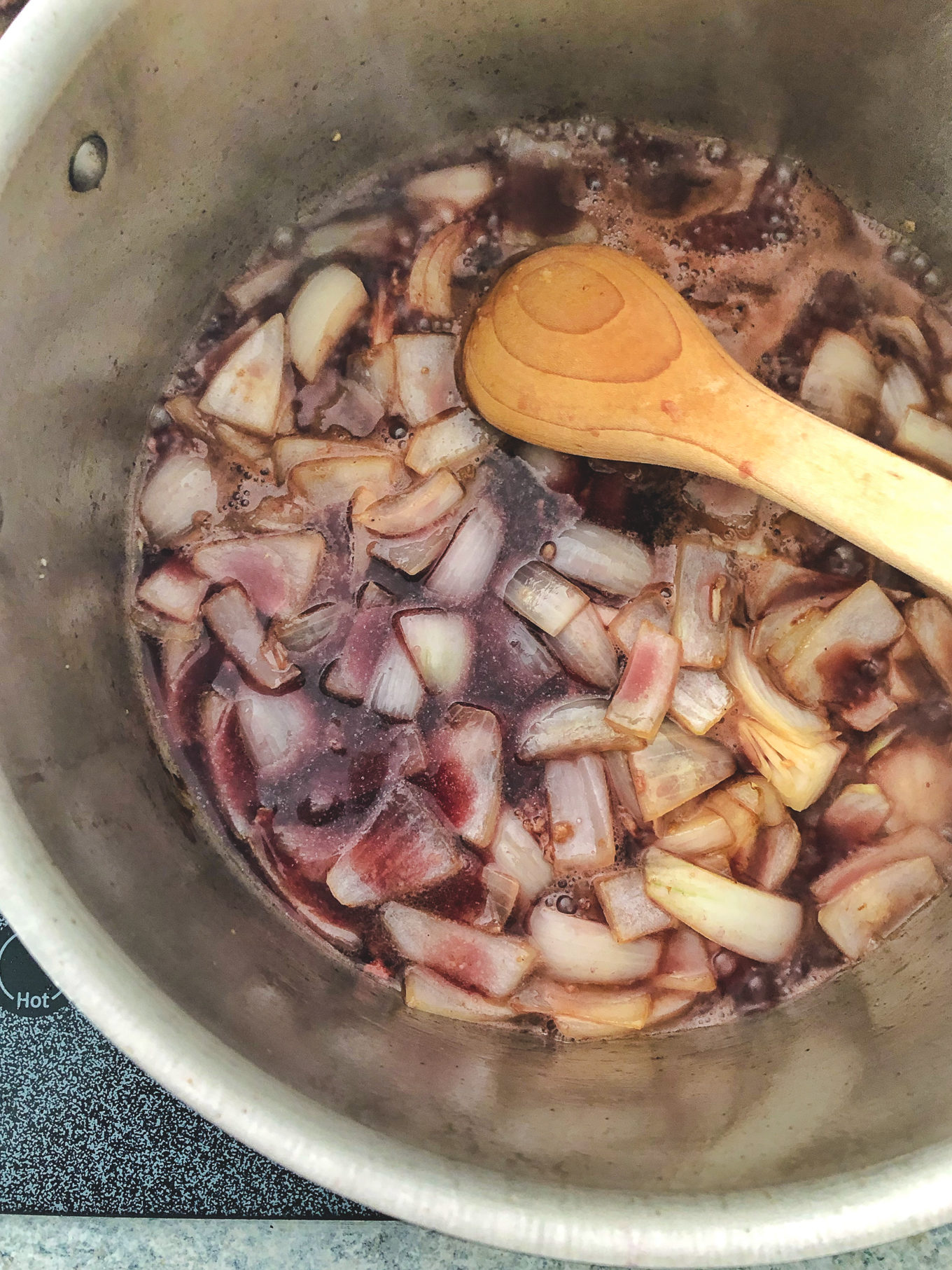stirring the onions with red wine for the pot roast recipe