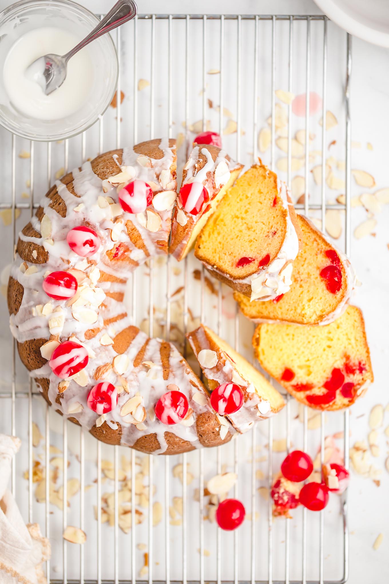 Easy Cherry Almond Bundt Cake - Made with yellow cake mix, instant vanilla pudding mix, almond extract, a jar of maraschino cherries, and sliced almonds, this easy bundt cake recipe is full of irresistible cherry almond flavor and effortlessly soft and tender. 