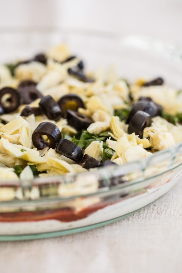 Layered Pepperoni Pizza Dip Recipe - a cheesy dip with artichokes, black olives, cream cheese, mozzarella, and basil that tastes just like a pepperoni pizza! The most delicious light appetizer!