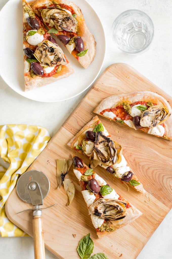 Grilled Artichoke, Olive and Pesto Flatbread Recipe - It's lighter than pizza (423 calories) and makes a better appetizer, too! Topped with kalamata olives, grilled artichokes, basil pesto, and mozzarella