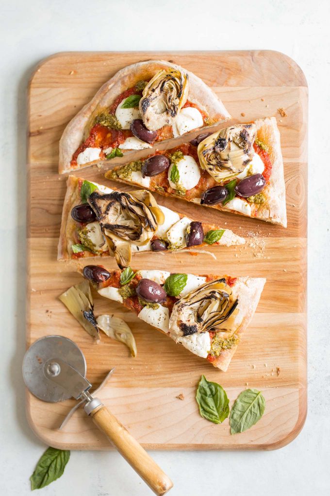Grilled Artichoke, Olive and Pesto Flatbread Recipe - It's lighter than pizza (423 calories) and makes a better appetizer, too! Topped with kalamata olives, grilled artichokes, basil pesto, and mozzarella