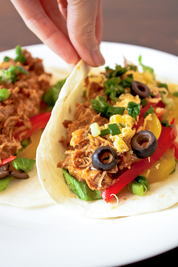 Slow Cooker Mexican Pulled Pork Tacos Recipe - this crock pot pulled pork recipe has outrageous flavor and is easily one of my most requested recipes! Always a hit!