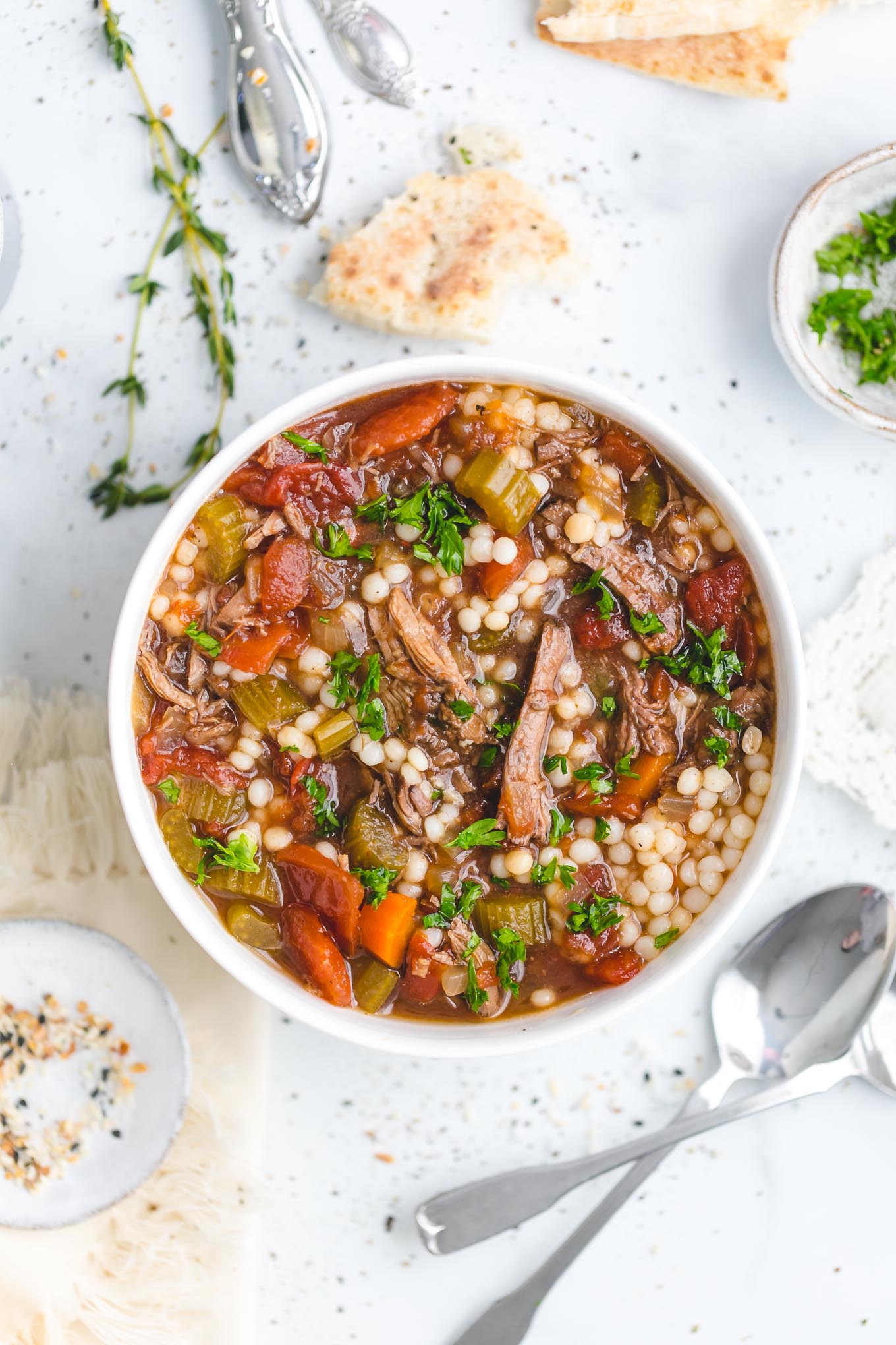 Slow Cooker Beef Soup with Couscous - This delicious slow cooker recipe has all the rich, savory flavor of a long-simmered beef stew, only it's lighter and more brothy, with fall-apart-tender chunks of beef and an aromatic beef broth made with garlic, onion, carrot, celery, bay leaves, fresh thyme, and a bit of soy sauce, which works to enhance that umami beef flavor.