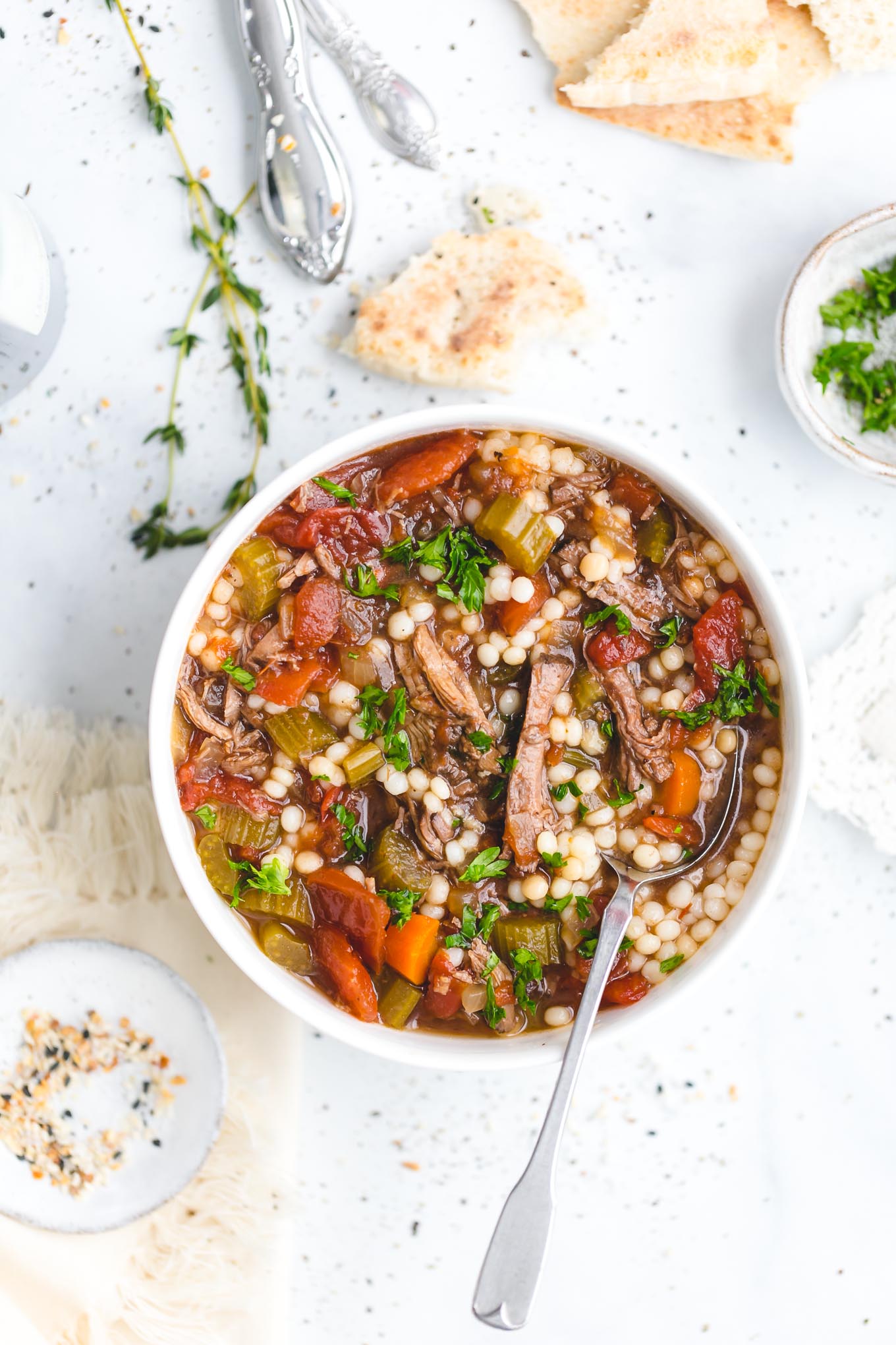 Slow Cooker Beef Soup with Couscous - This delicious slow cooker recipe has all the rich, savory flavor of a long-simmered beef stew, only it's lighter and more brothy, with fall-apart-tender chunks of beef and an aromatic beef broth made with garlic, onion, carrot, celery, bay leaves, fresh thyme, and a bit of soy sauce, which works to enhance that umami beef flavor.