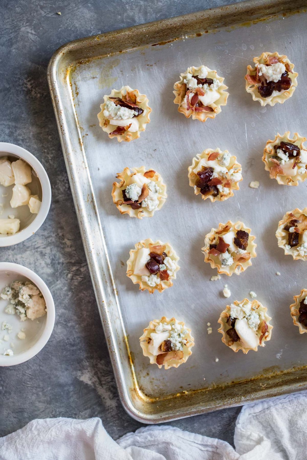 Sweet and Savory Medjool Date, Bacon, and Brie Tarts - Flaky mini fillo dough tarts make an easy, delicious appetizer - and these are perfectly sweet and savory, with brie, blue cheese, bacon, and medjool dates. 