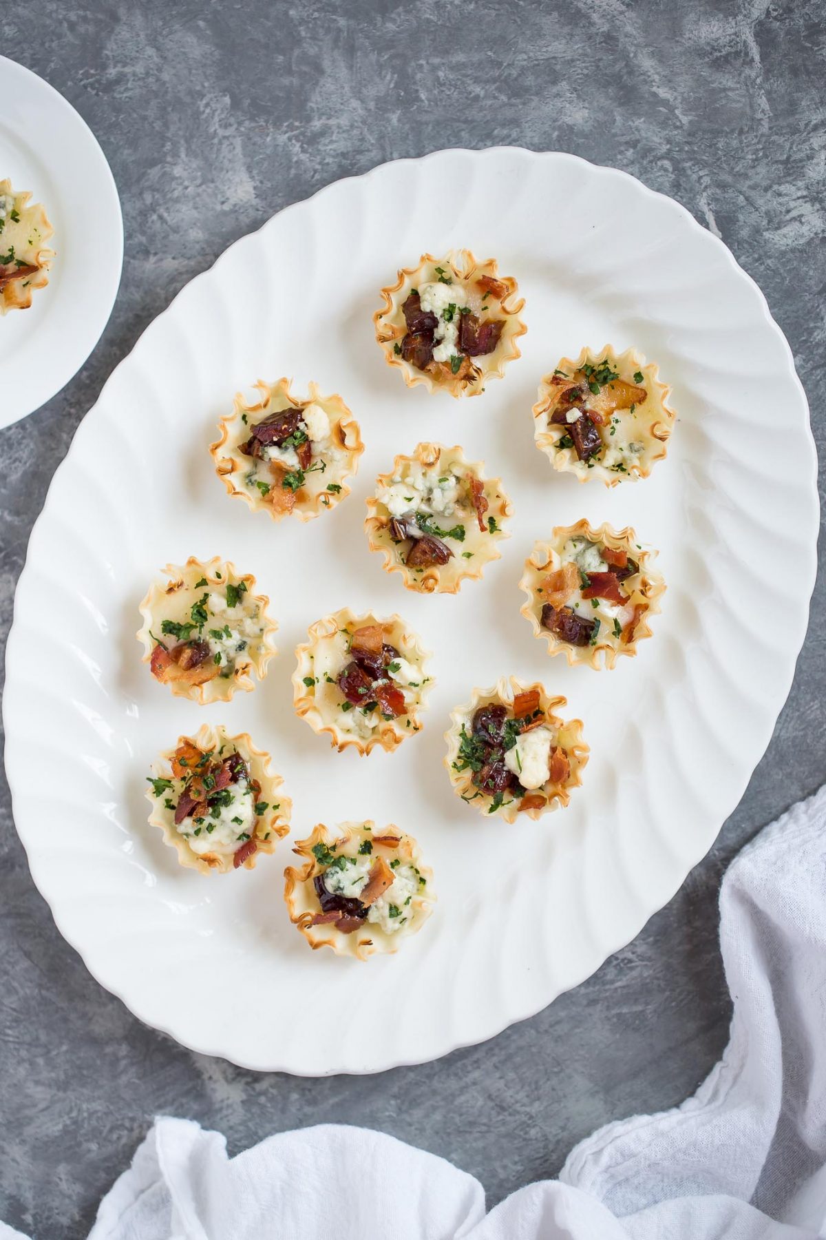 Sweet and Savory Medjool Date, Bacon, and Brie Tarts - Flaky mini fillo dough tarts make an easy, delicious appetizer - and these are perfectly sweet and savory, with brie, blue cheese, bacon, and medjool dates. 