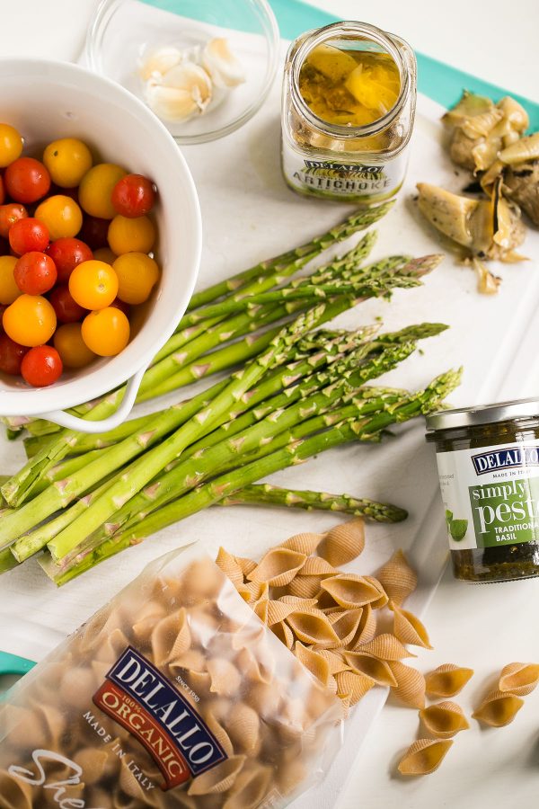 Whole Wheat Pasta Salad with Pesto, Asparagus and Roasted Tomatoes - A flavor-packed pasta salad can be easy and healthy, too, and this recipe is proof. Slather DeLallo whole wheat shells in basil pesto, then toss them with roasted asparagus, sweet blistered tomatoes, charred artichokes, and salty bits of prosciutto. All this for only 249 calories per serving