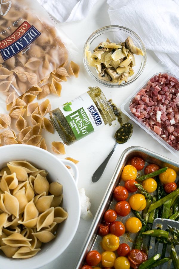 Whole Wheat Pasta Salad with Pesto, Asparagus and Roasted Tomatoes - A flavor-packed pasta salad can be easy and healthy, too, and this recipe is proof. Slather DeLallo whole wheat shells in basil pesto, then toss them with roasted asparagus, sweet blistered tomatoes, charred artichokes, and salty bits of prosciutto. All this for only 249 calories per serving