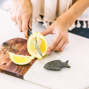 Women cutting lemons with lucky fish on the side