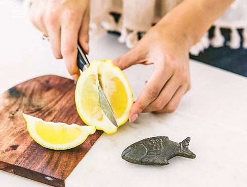 Women cutting lemons with lucky fish on the side