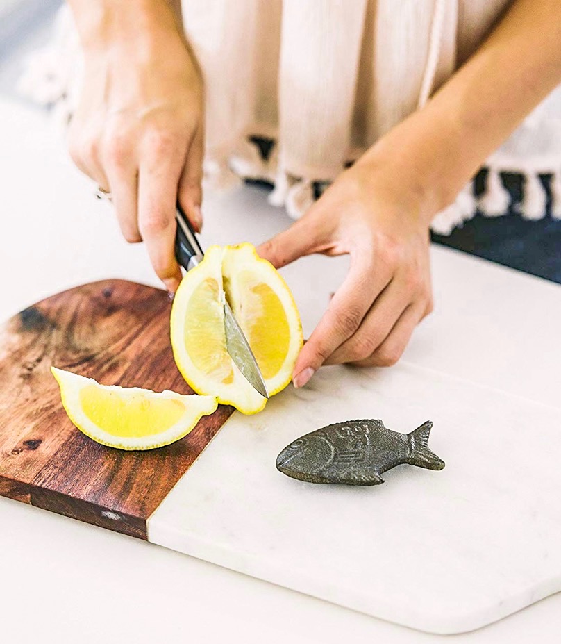 Women cutting lemons with lucky fish on the side